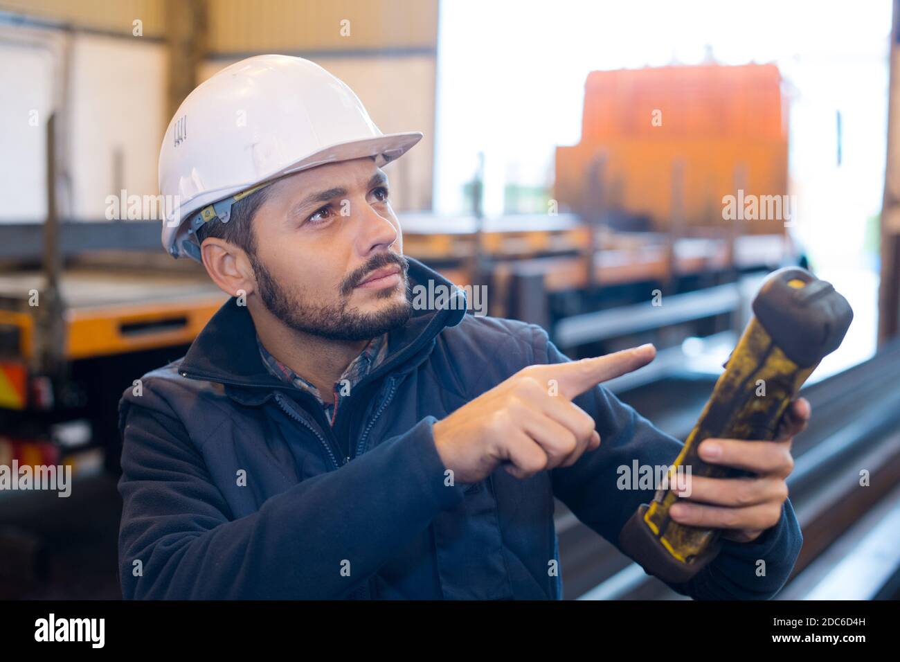 operatore che manipola la gru in magazzino Foto Stock