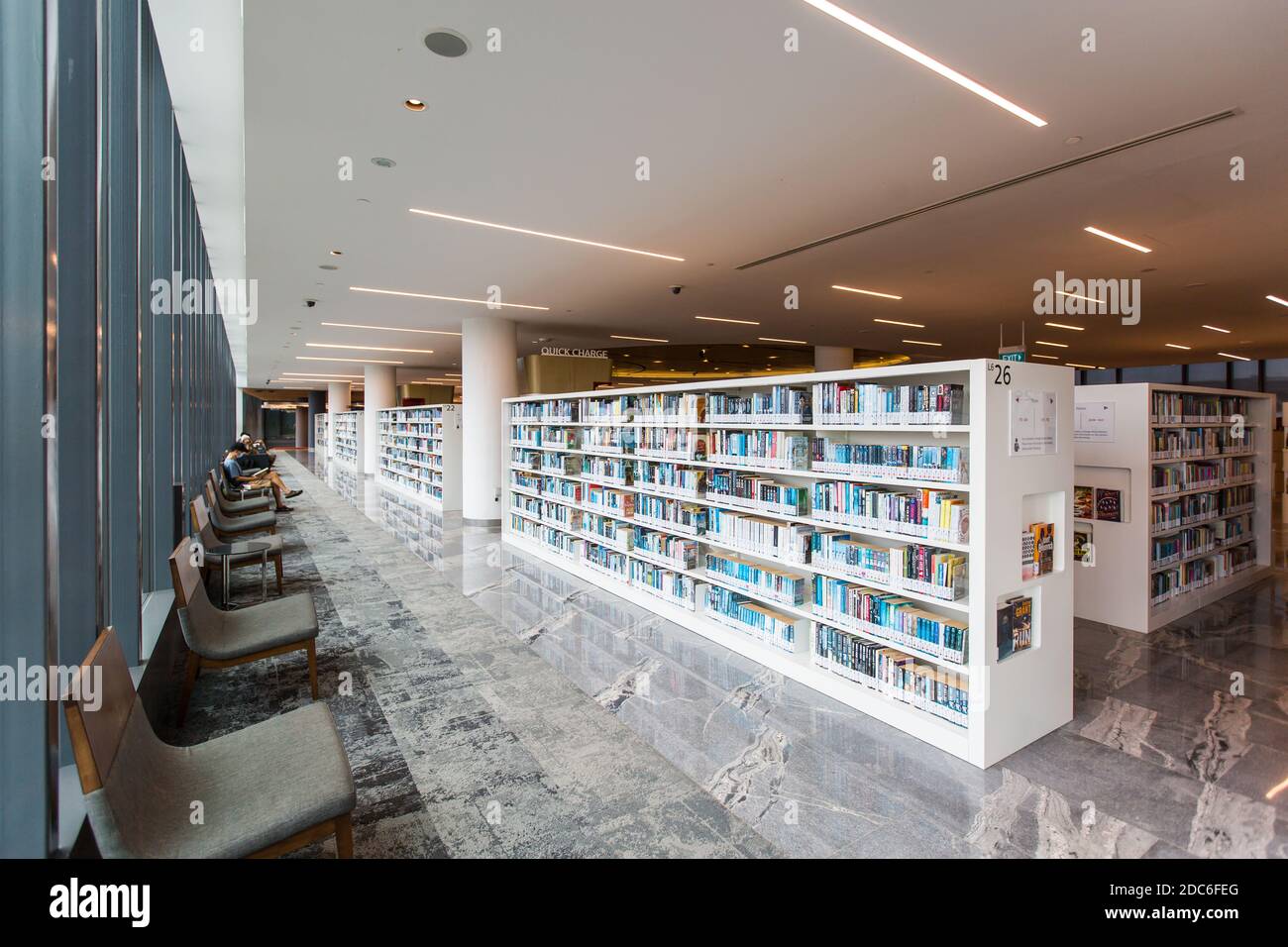 Una spaziosa libreria interna con comodi posti a sedere vicino alla finestra con illuminazione naturale per i lettori pubblici a leggere libri. Singapore. Foto Stock