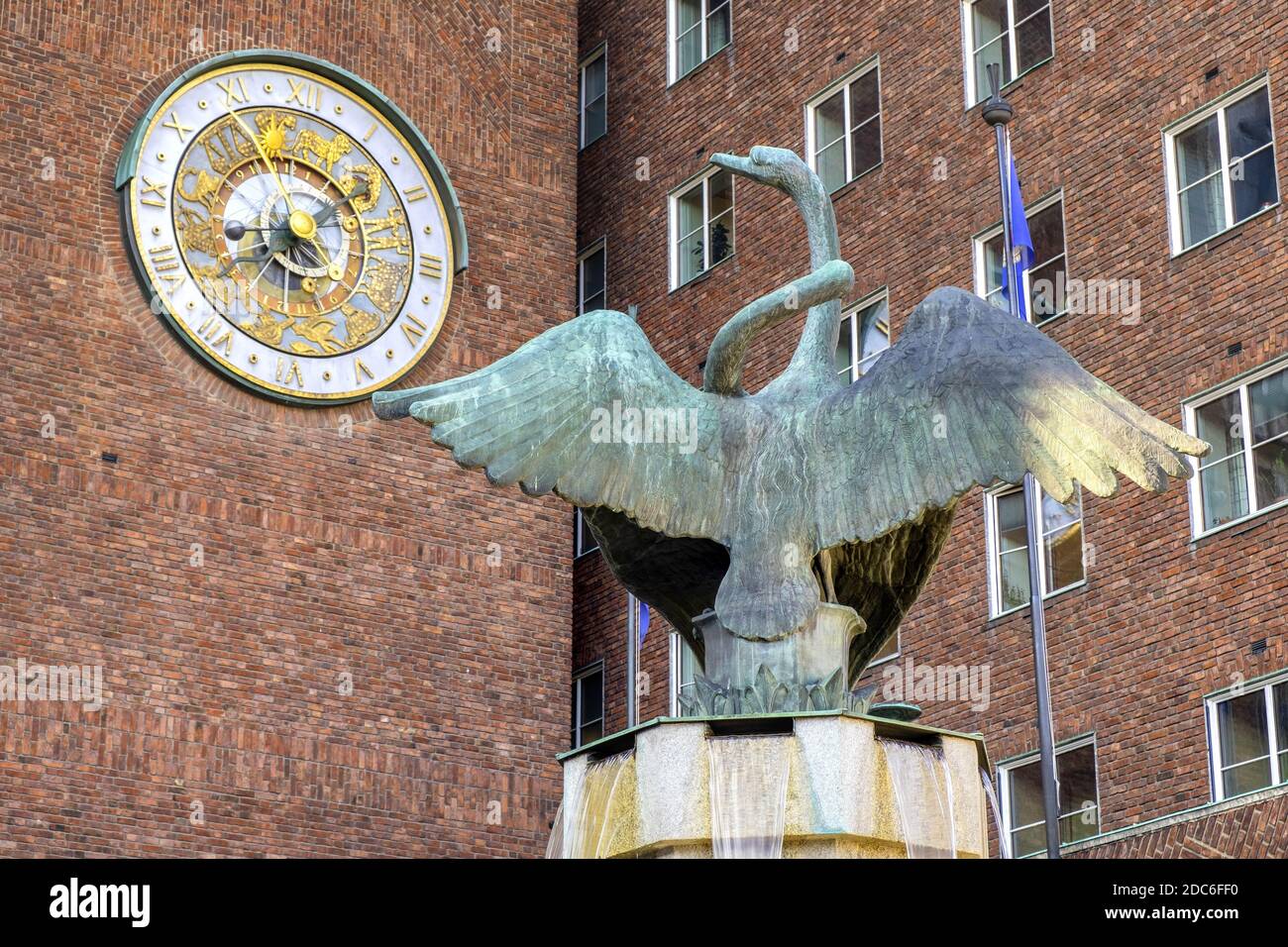Oslo, Ostlandet / Norvegia - 2019/08/30: Fontana di Swan scultura di Dyre VAA di fronte al Municipio edificio storico - Radhuset - con torre astronomica Foto Stock