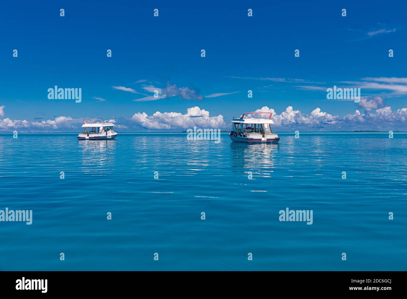 Yacht di lusso a vela sull'oceano alle Maldive, isola tropicale sullo sfondo. Concetto di vacanza di viaggio e viaggio in barca Foto Stock