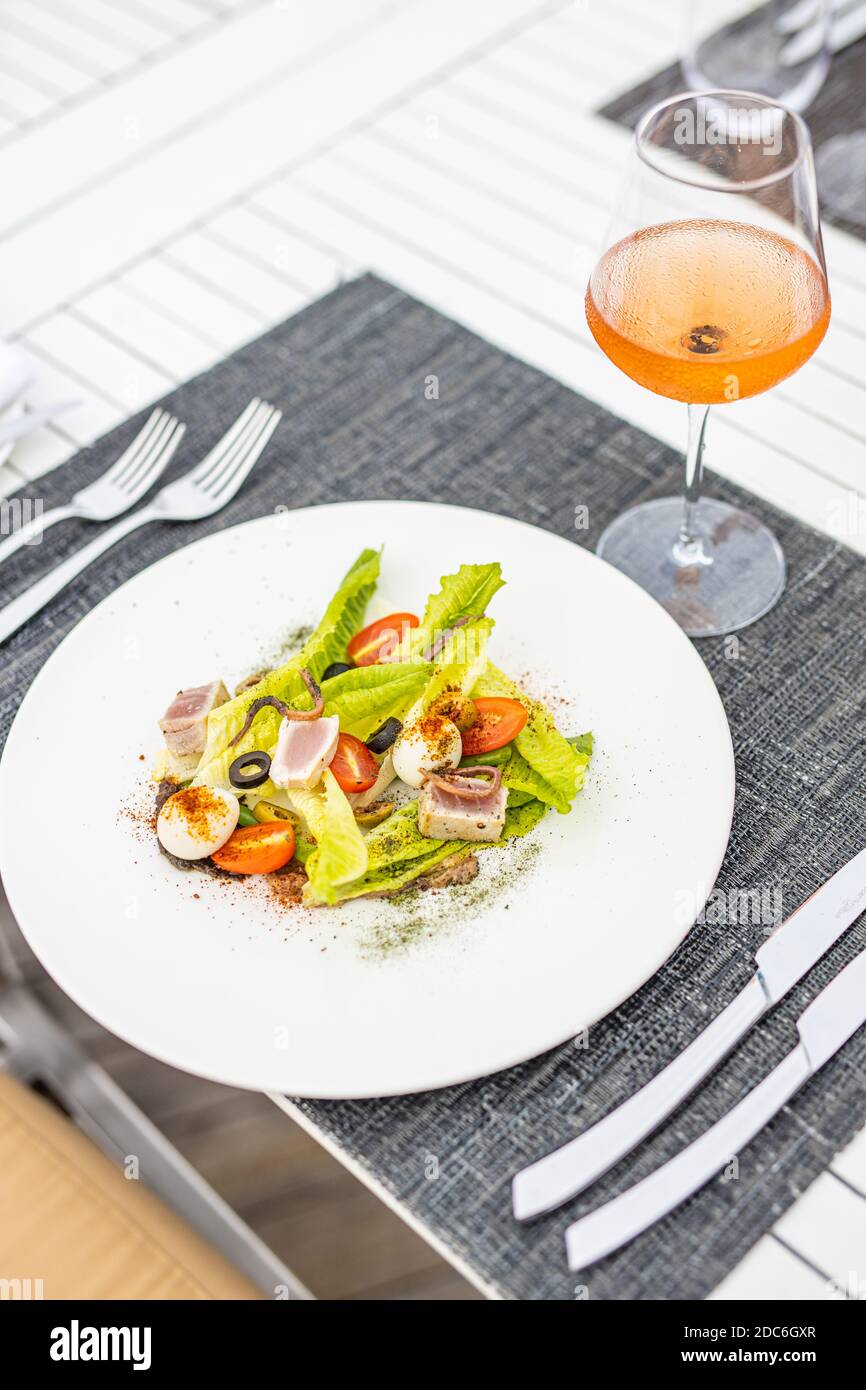 Salmone con insalata di spinaci, pomodori ciliegini, lattughella, baby spinaci, menta e basilico. Cibi fatti in casa. Un concetto per un gustoso e pasto sano Foto Stock