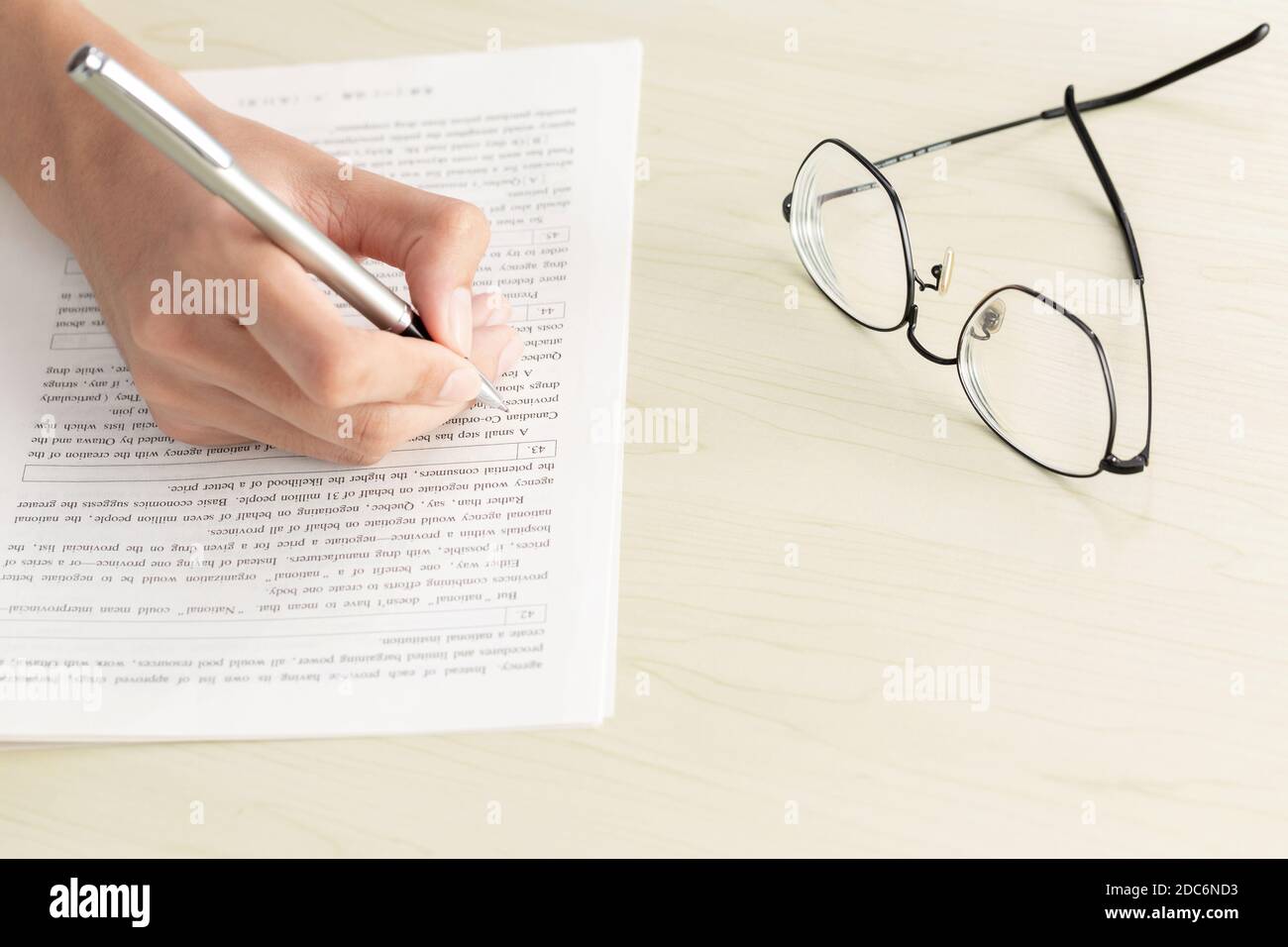 Una mano di donna d'affari che scrive su carta in ufficio Foto Stock Una mano di donna d'affari che scrive su carta in ufficio Foto Stock