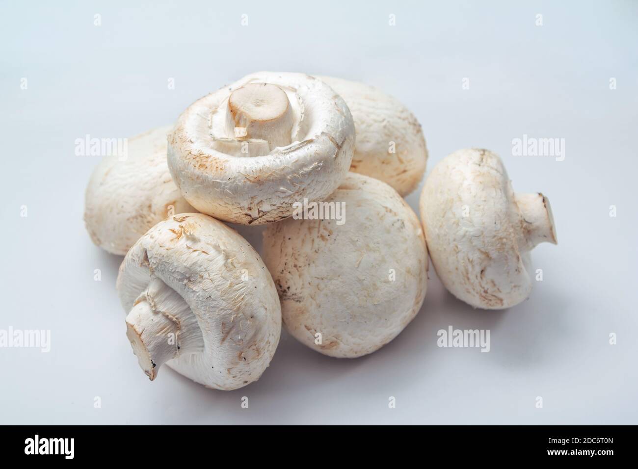Funghi champignon crudi freschi pronti per la cottura sul tavolo. Foto Stock