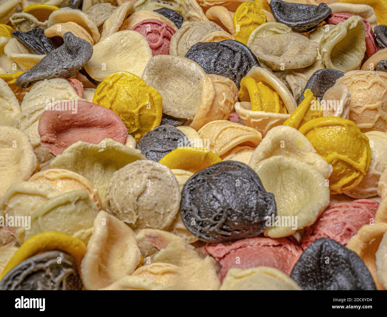 Primo piano POV di forme multicolore, senza cottura, conchiglie di pasta secca. Foto Stock