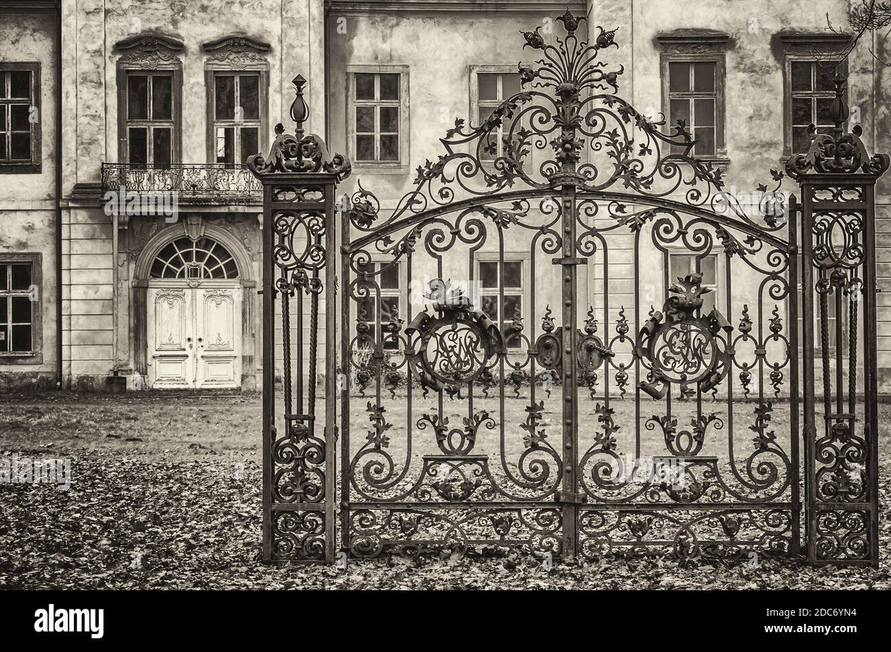 Un vecchio cancello di ferro è situato di fronte ad una casa padronale barocca dilapido, Ivenack Manor, Meclemburgo Pomerania, Germania. Foto Stock
