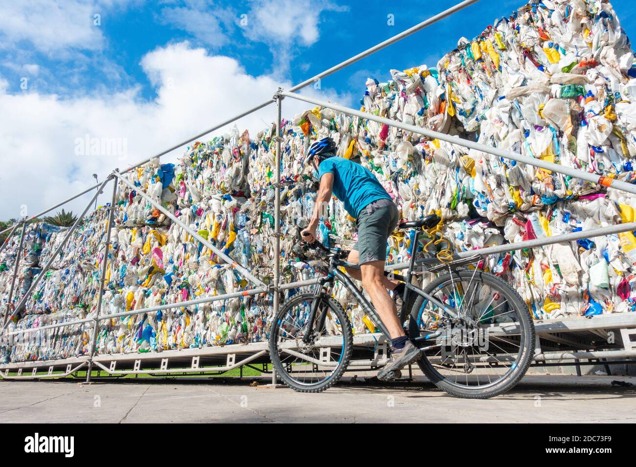 Las Palmas, Gran Canaria, Isole Canarie, Spagna. 19 novembre 2020. Un ciclista passa accanto a rifiuti plastici compattati nel parco di Las Palmas sulla Gran Canaria. L'impianto fa parte di una mostra chiamata 'Biotopias 2' che mira a sensibilizzare l'opinione pubblica sul viaggio verso l'esterno dei rifiuti di plastica. Credit: Alan Dawson/Alamy Live News Foto Stock