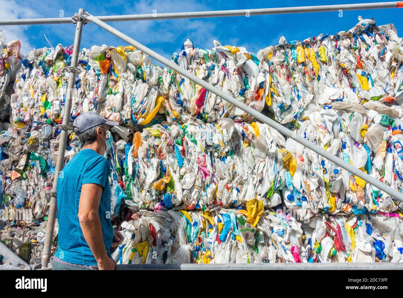 Las Palmas, Gran Canaria, Isole Canarie, Spagna. 19 novembre 2020. Un uomo che indossa una copertura facciale accanto alla plastica di scarto compattata nel parco a Las Palmas su Gran Canaria. L'impianto fa parte di una mostra chiamata 'Biotopias 2' che mira a sensibilizzare l'opinione pubblica sul viaggio verso l'esterno dei rifiuti di plastica. Credit: Alan Dawson/Alamy Live News Foto Stock