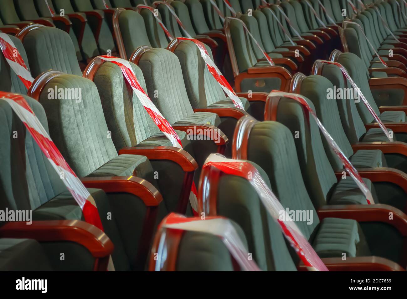 Necessità di sedersi su una sedia separata da un nastro nel cinema, teatro, auditorium. Mantenere una distanza sociale sicura in luoghi pubblici, incontri di Foto Stock