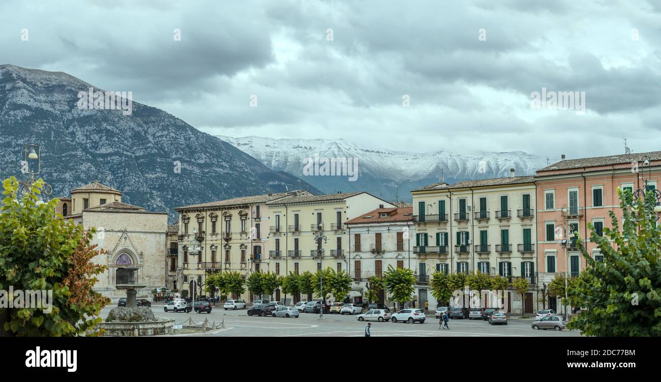 SULMONA, ITALIA - settembre 27 2020: Paesaggio urbano con persone che passeggiano in piazza Garibaldi, mentre la neve Maiella punta incombe sullo sfondo, girato in luminoso Foto Stock