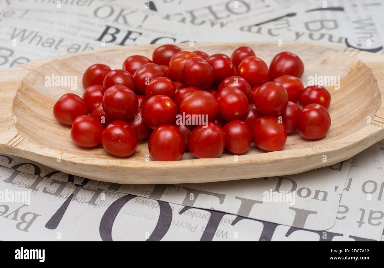 Pomodori ciliegini su un vassoio di legno Foto Stock