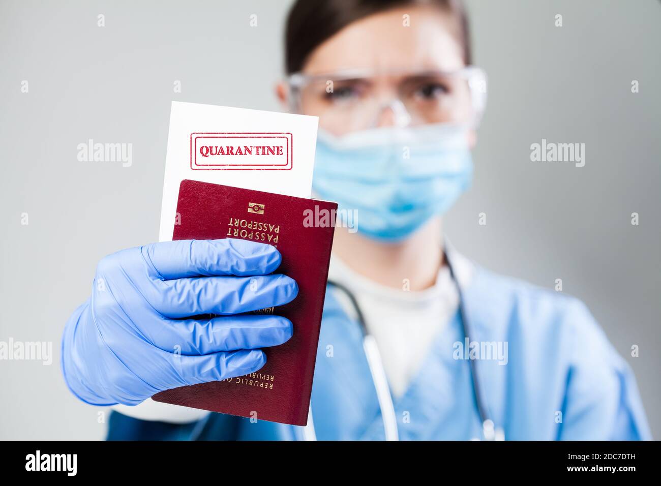 Medico o infermiere presso il controllo di sicurezza doganale dell'aeroporto in possesso di un passaporto, nessun divieto di entrata quarantena e di isolamento ordine, COVID-19 epidemia di malattia virale Foto Stock