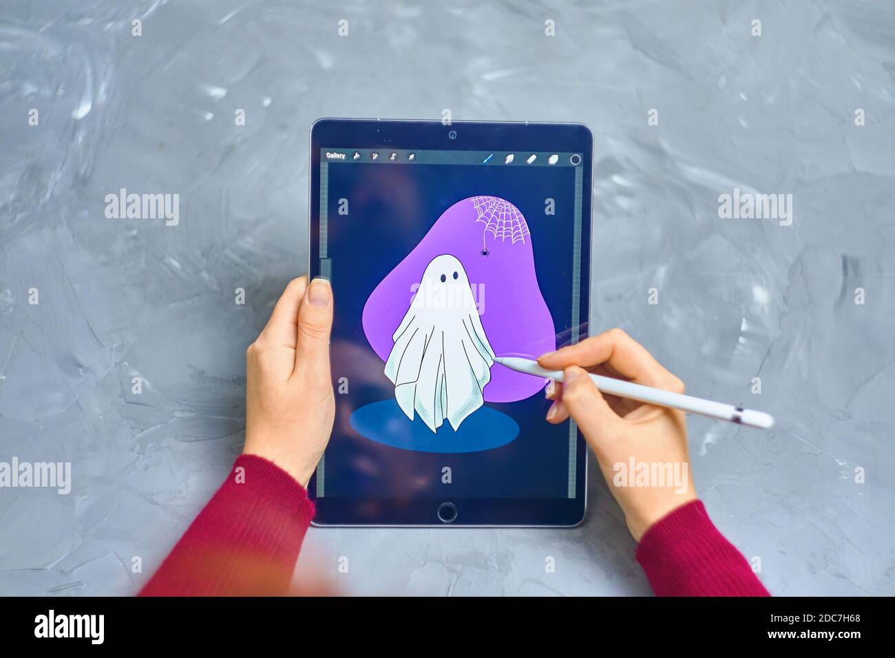 Woman Illustrator disegna Ghost su iPad Pro in un programma di procreate utilizzando una matita di mela. Illustrator digitale. Lavoro freelance come progettista. Bishkek, Kirghizistan - 21 gennaio 2019. Foto Stock