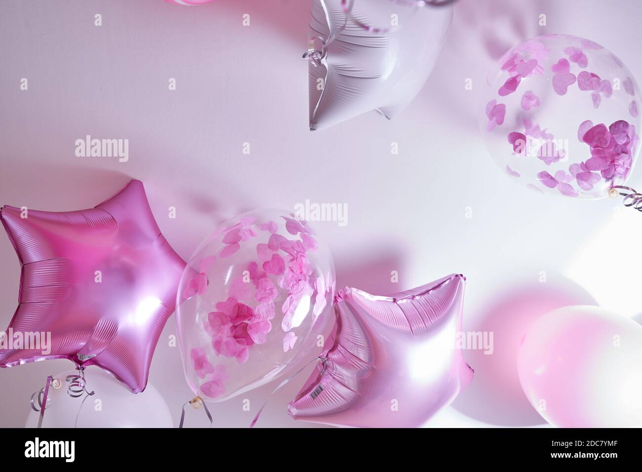Palloncini rosa, bianchi e trasparenti con petali di rosa gonfiati