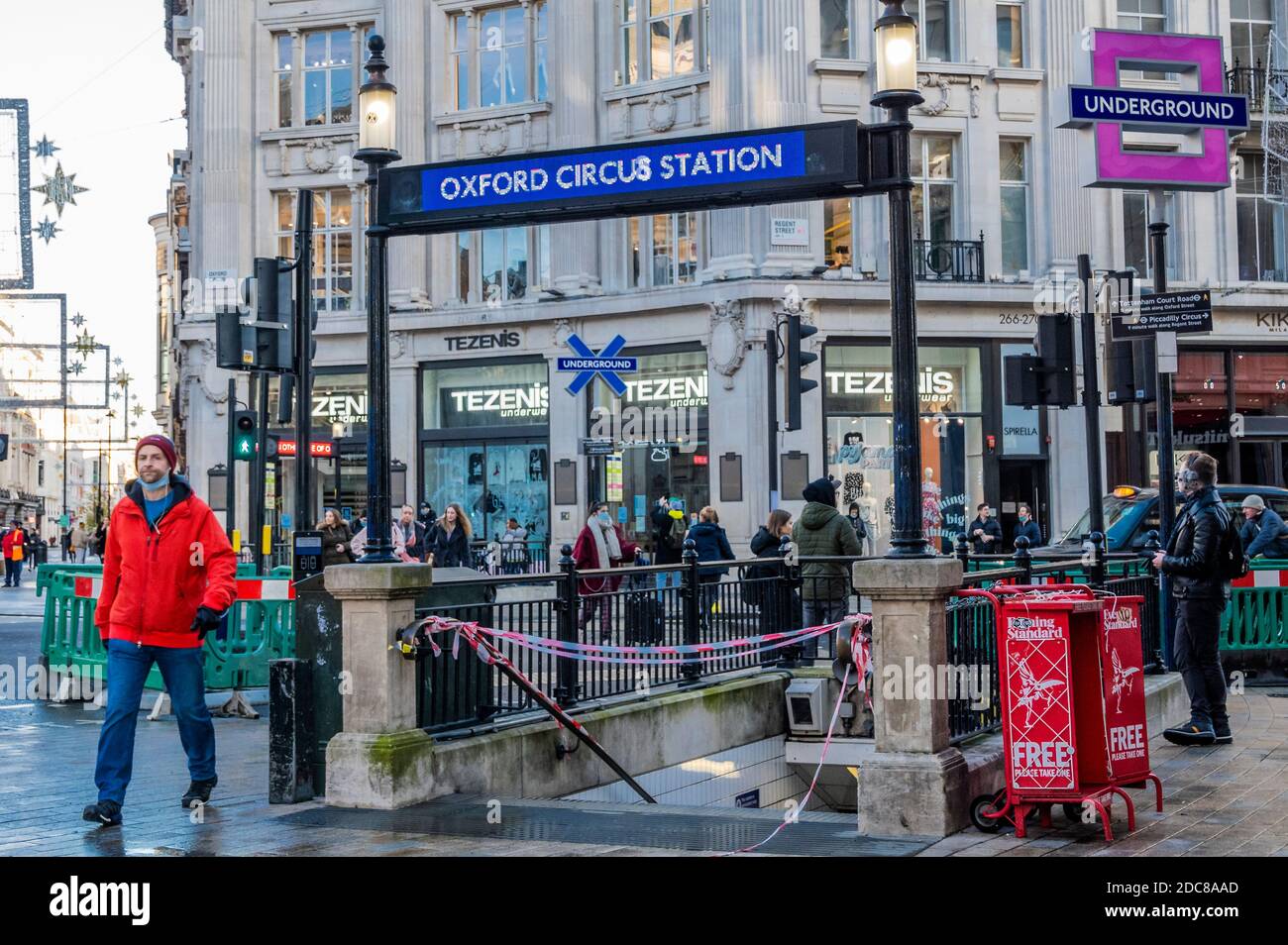 Londra, Regno Unito. 19 Nov 2020. In tempo per l'arrivo della console PS5 di Oxford Circus è stato aggiornato con il marchio della console quadrato, cerchio, triangolo e croce. All'interno della stazione a tubo vengono visualizzati i quattro simboli accanto al nome della stazione e alla rotonda. Per caso (o no) il negozio Oxford Circus Microsoft (produttore del suo principale concorrente X-box) si trova proprio fuori da una di queste uscite. La gente è ancora fuori nel centro di londra, nonostante il nuovo blocco che è ora in vigore. Le luci di Natale sono accese ma i negozi sono chiusi. Molte persone indossano maschere, anche all'esterno. Credit: Guy Bell/Alamy Liv Foto Stock