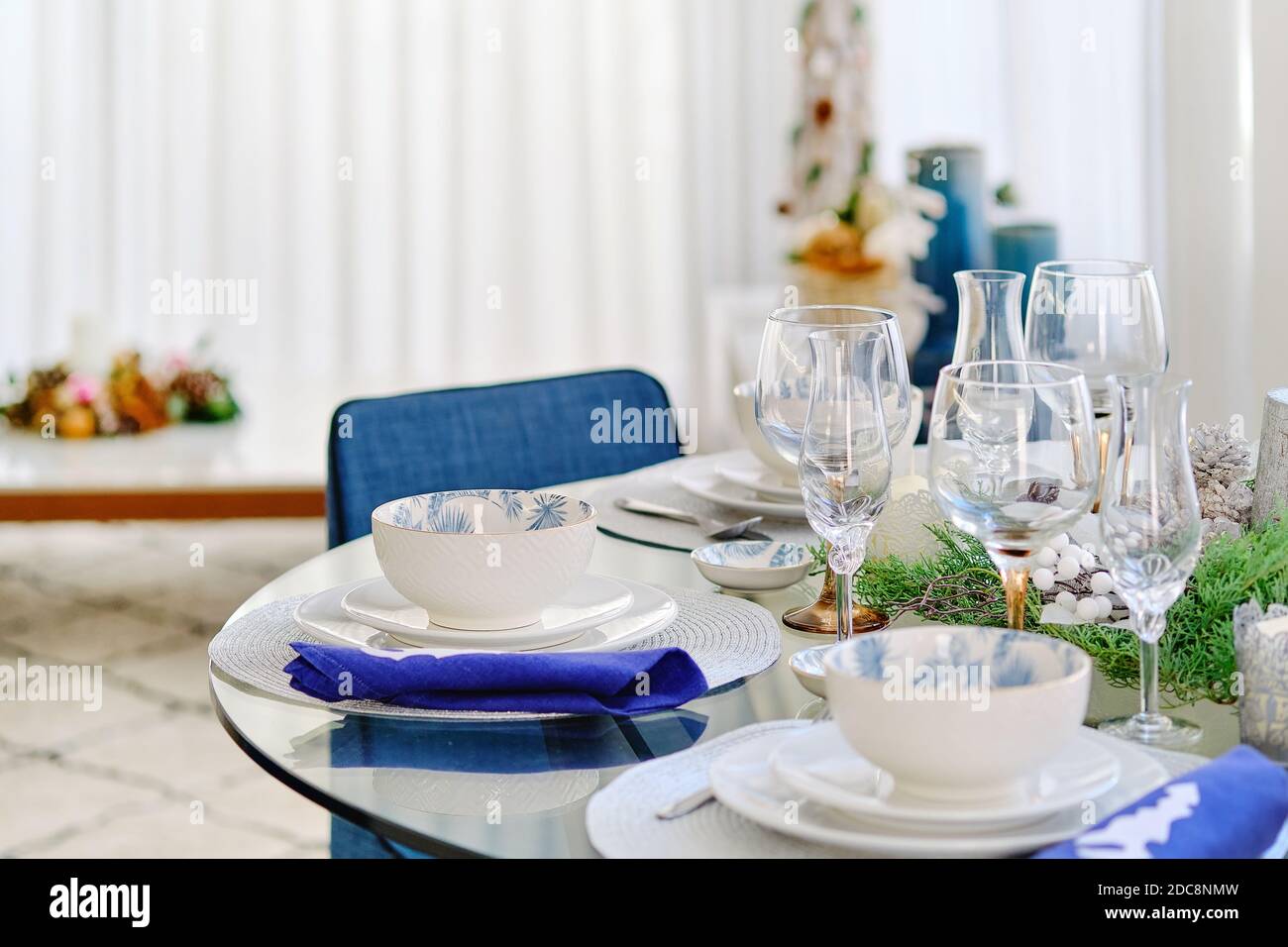 Cena di Natale e concetto di festa di Capodanno. Primo piano vista bianco stoviglie decoro tovaglioli blu sul tavolo pronto per la ricezione quest, Foto Stock