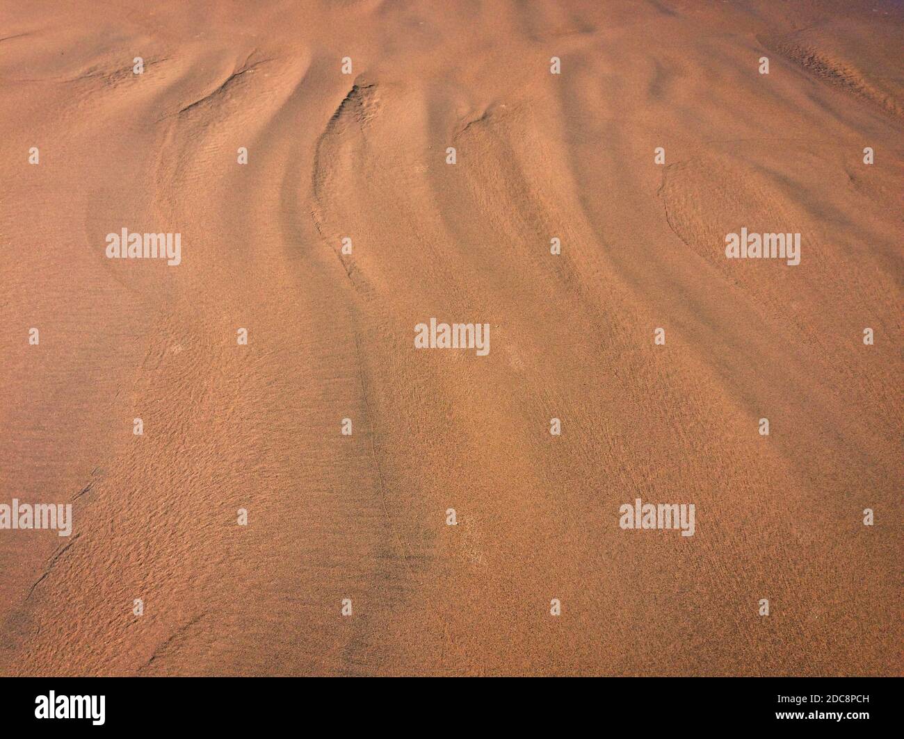 motivi dalle onde e vento sulla sabbia, sabbia di un colore insolito Foto Stock