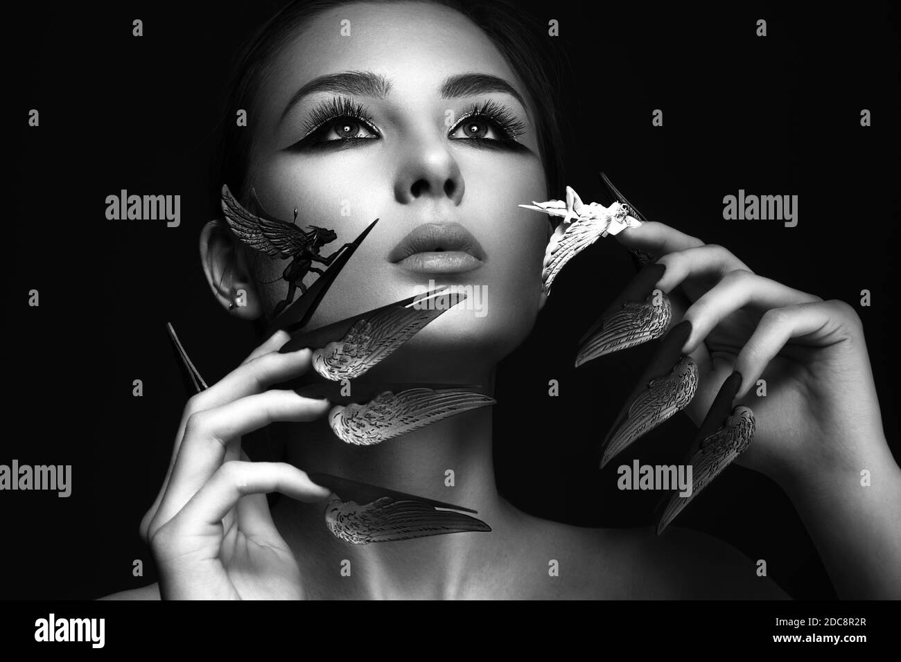 Bella donna con trucco d'arte, unghie lunghe creative. Manicure di disegno. Viso di bellezza. Foto Stock