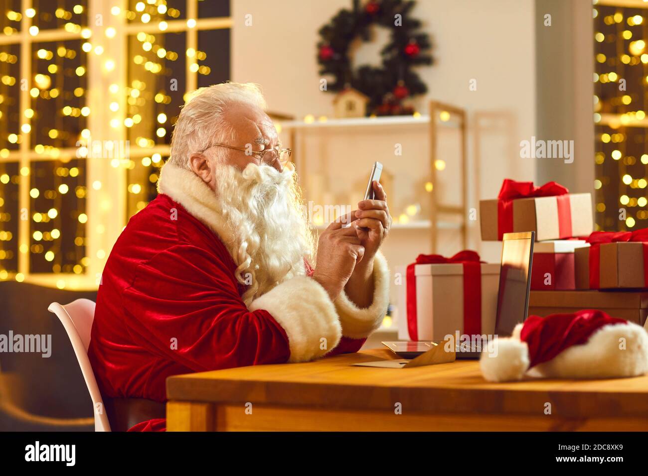 Moderno Babbo Natale messaggi di testo e l'ordine presenta la consegna utilizzando applicazione telefono Foto Stock