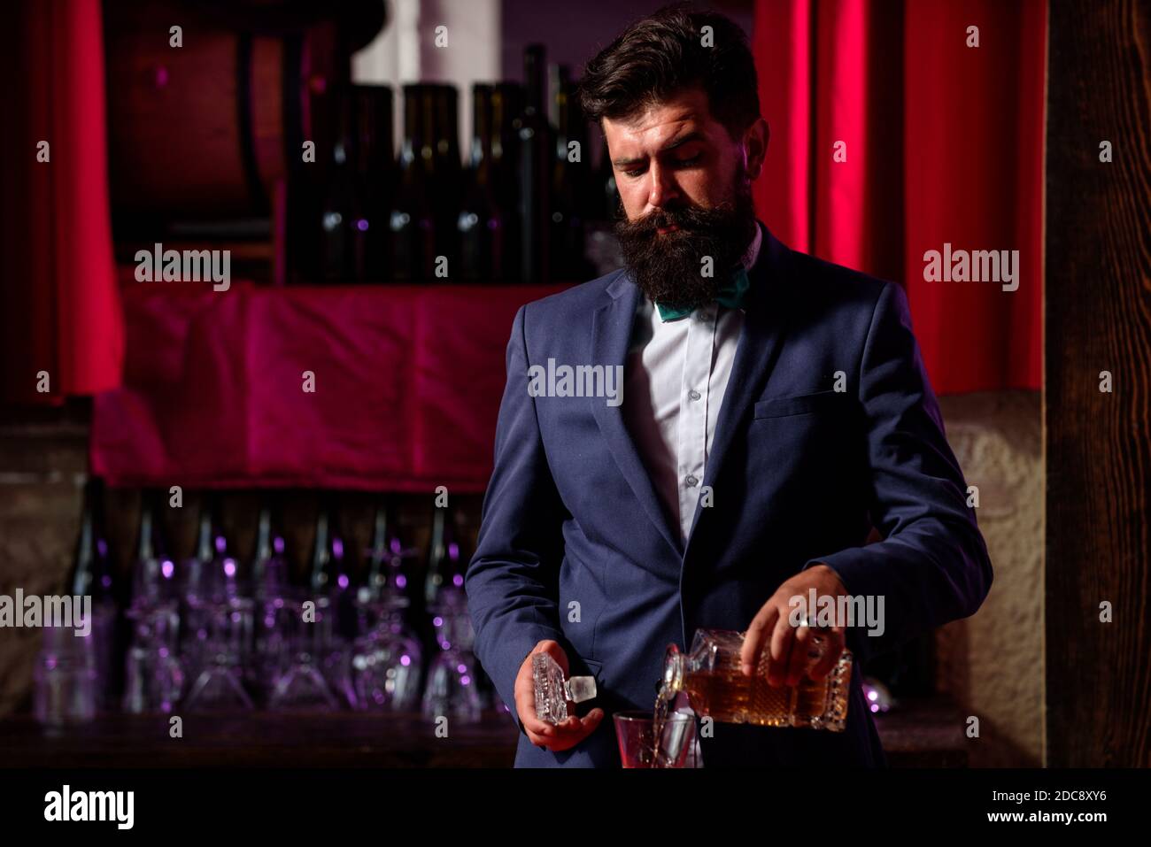 Barman che versa il brandy in un bicchiere di whisky. Bevanda alcolica. Foto Stock