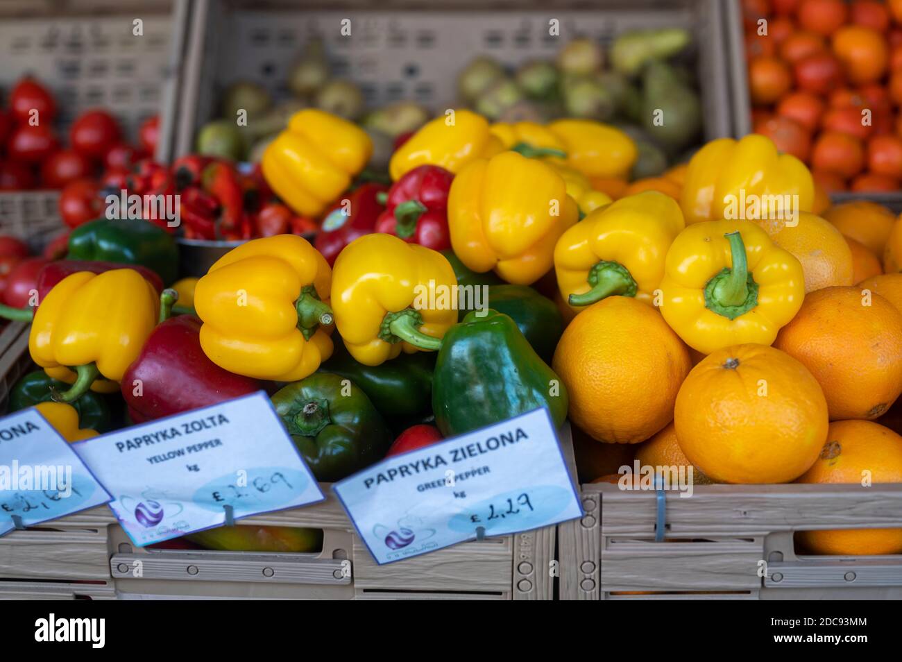 Verdure biologiche fresche e frutta messe mescolate in una bancarella di mercato, i nomi sono scritti in polacco e inglese Foto Stock
