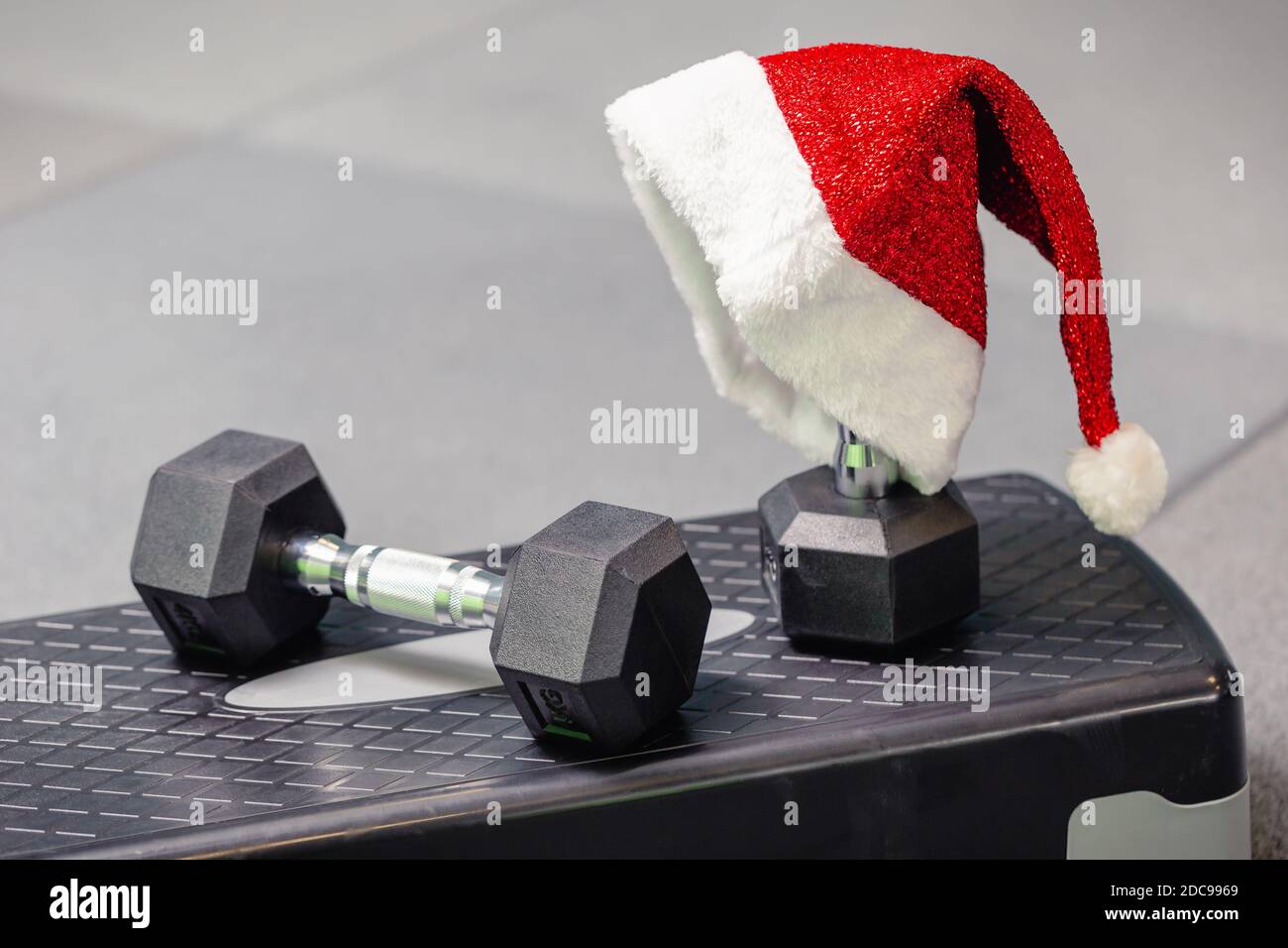 Cappello di Babbo Natale in palestra. Concetto di sport su Natale e Capodanno. Concetto di fitness, stile di vita sano e attivo. Foto Stock