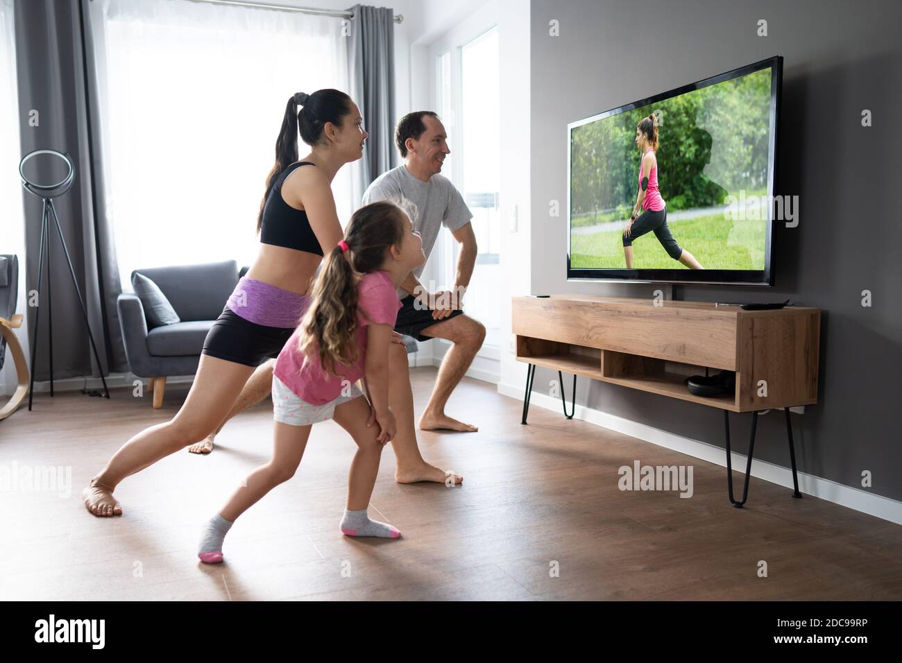 Fit Family doing Home Online Stretching Yoga Fitness esercizio Foto Stock