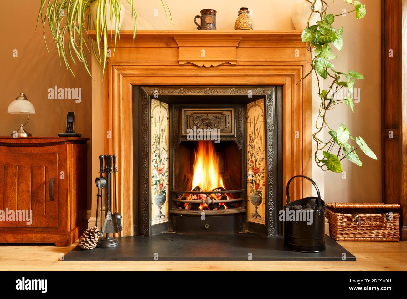 Accogliente camino invernale soggiorno, con camino aperto con fiamme reali che bruciano carbone, interni casa UK Foto Stock