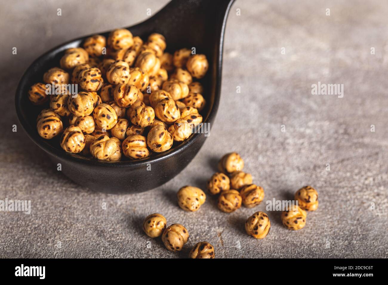 Ceci gialli arrostiti in ciotola nera su fondo di pietra (nome turco; sari leblebi). Foto Stock