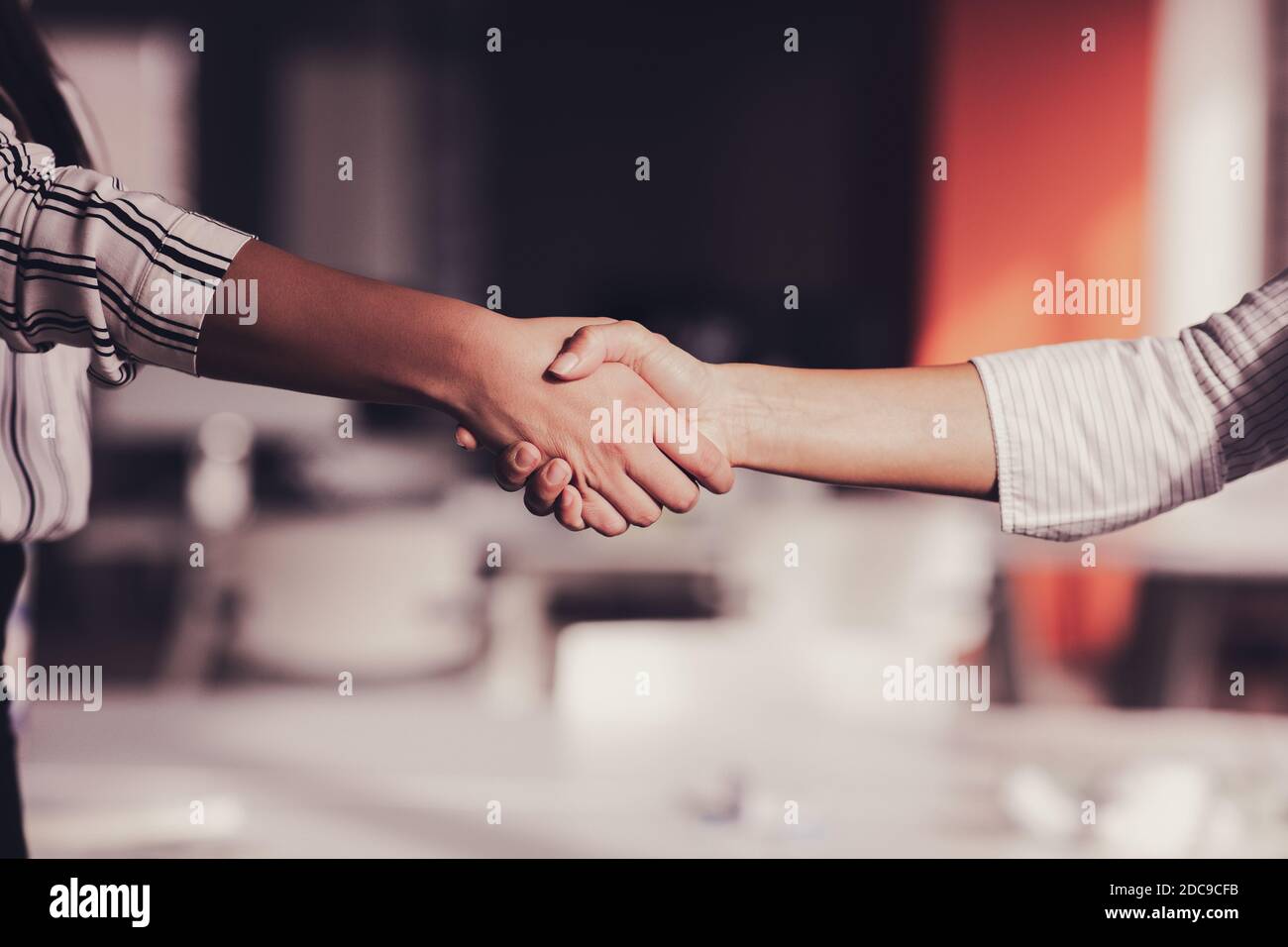 Uomo d'affari e donna d'affari che scuotono le mani sopra la scrivania Foto Stock