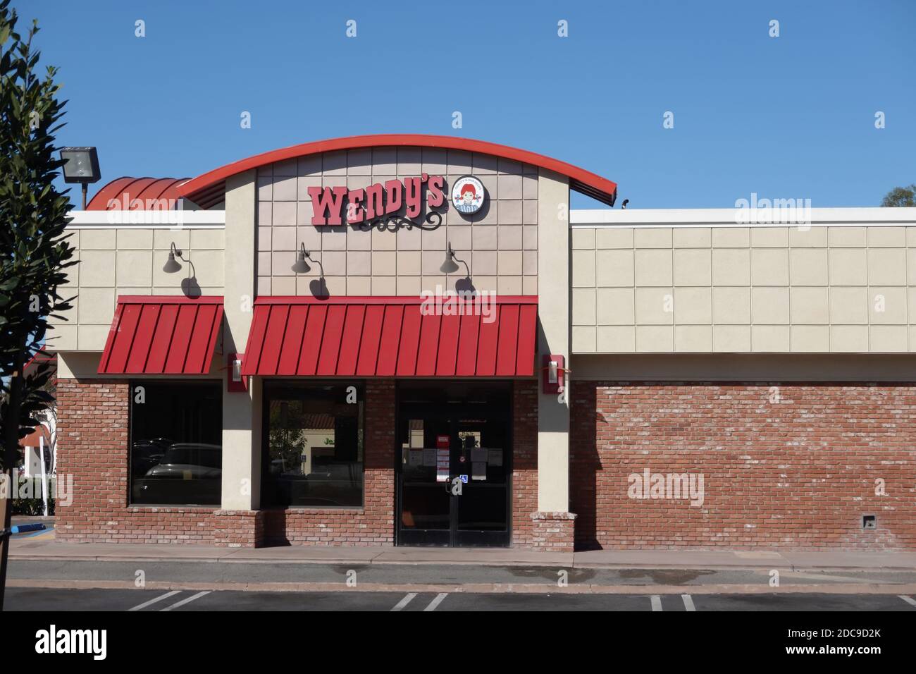 Il cartello del ristorante fast food Wendy's e il logo sopra l'entrata su una parete esterna Foto Stock