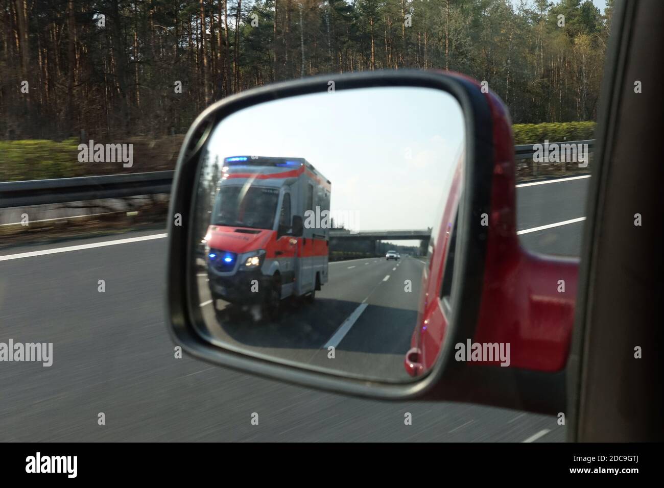 06.04.2019, Michendorf, Brandeburgo, Germania - ambulanza del Johannitre sulla A10 nello specchietto retrovisore sinistro di un'autovettura. 00S190406D242CA Foto Stock