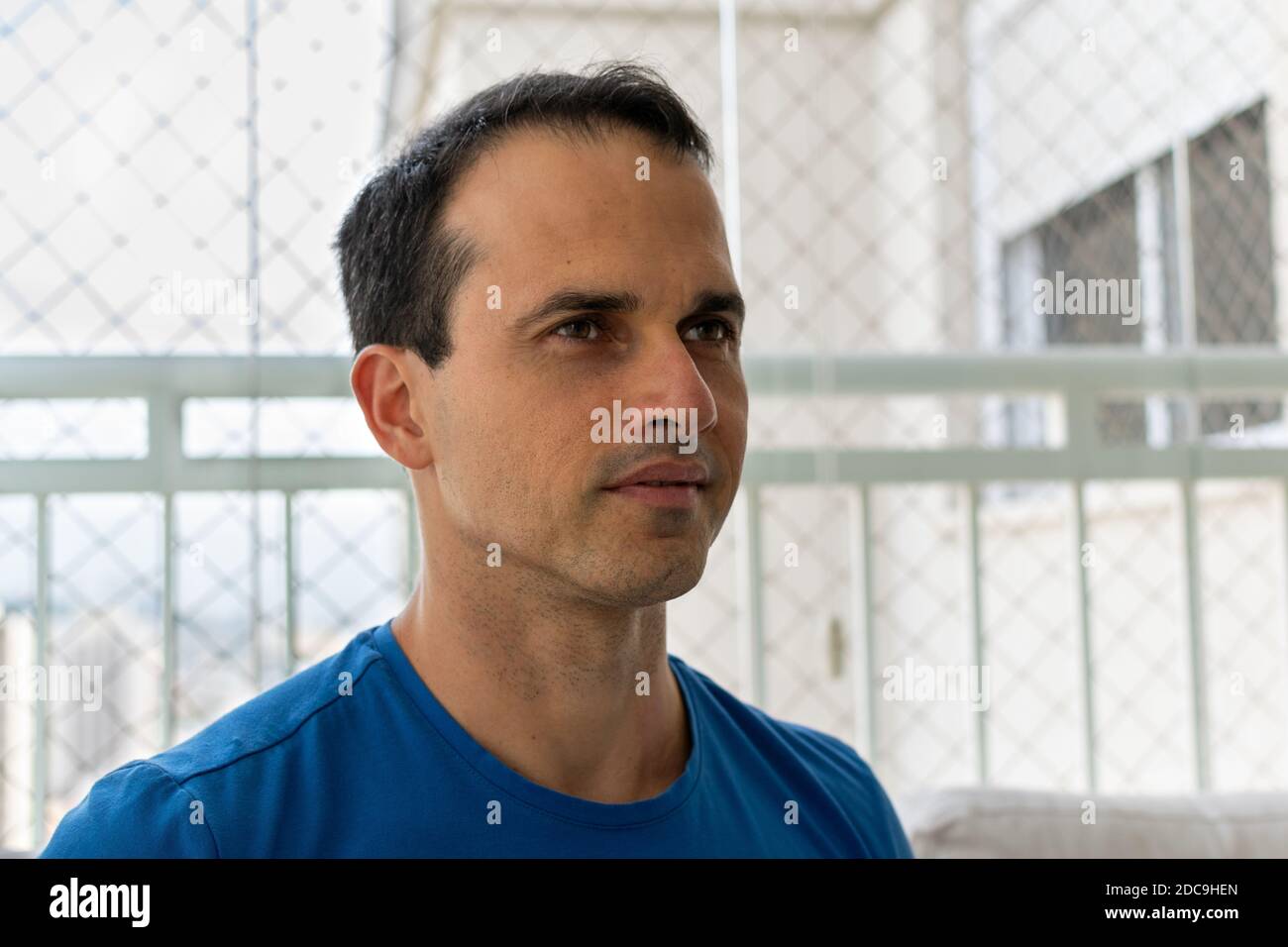 uomo di 43 anni in camicia blu guardando la diagonale. Foto Stock
