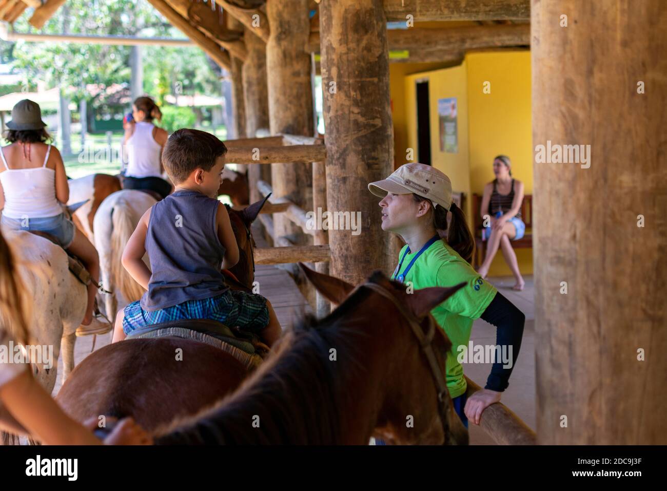 Ragazzo che viene istruito su come cavalcare un cavallo al Ranch Hotel Mazzaropi. Foto Stock