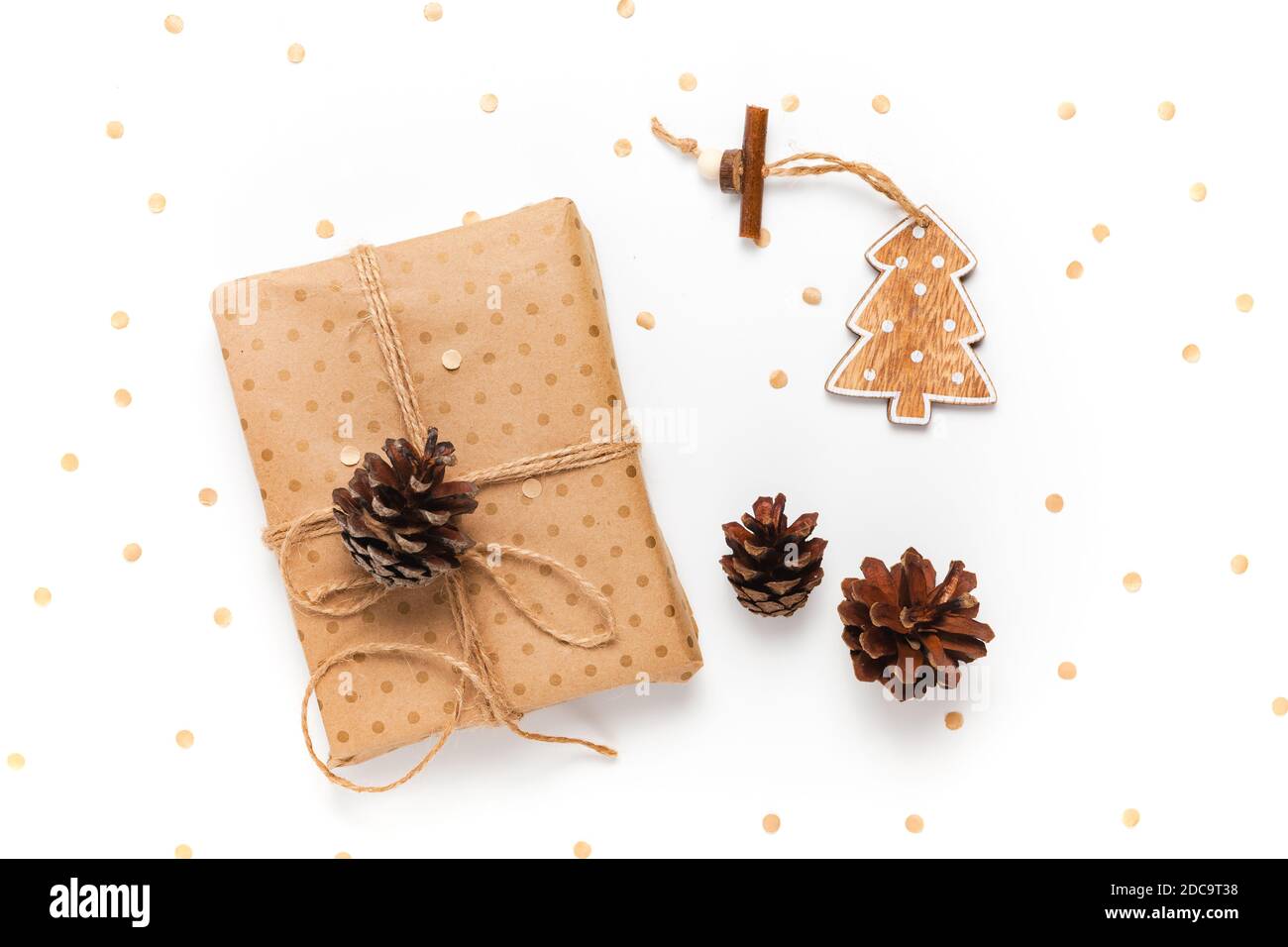 Confezione regalo avvolta in carta artigianale decorata con cono di pino su sfondo bianco Foto Stock