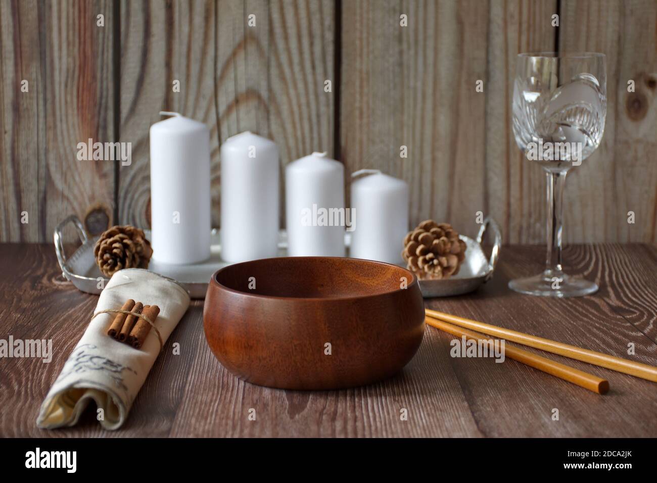 Disposizione rustica del tavolo con ciotola di legno e candele su legno sfondo Foto Stock