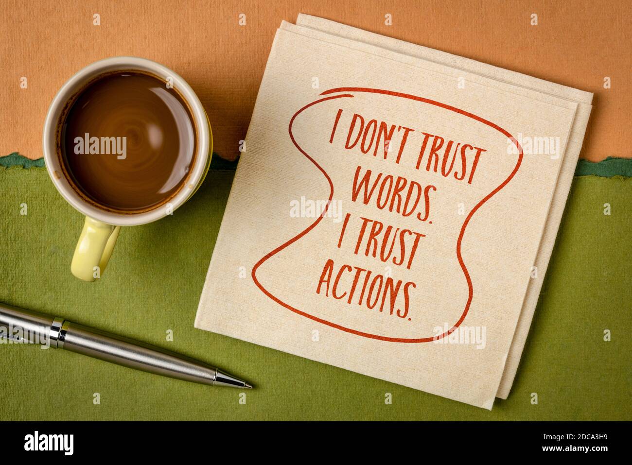 Non mi fido delle parole. Mi fido delle azioni. Calligrafia ispirata su un tovagliolo con una tazza di caffè. Concetto di sviluppo personale. Foto Stock