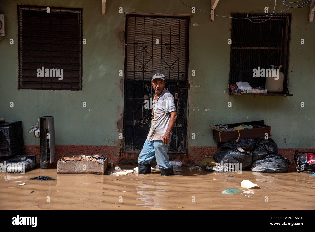 Un uomo cammina attraverso le acque alte del ginocchio in una strada allagata.l'uragano Iota ha colpito la costa del Nicaragua il 16 novembre come una tempesta di categoria 4. È stata la seconda categoria 4 a fare le frane in Nicaragua entro due settimane e di nuovo ha portato le precipitazioni catastrofiche in Honduras. I 2 milioni di persone colpite dall'uragano ETA sono nuovamente devastati. Il rischio di allagamenti e frangenti è estremamente elevato a causa del 100% di saturazione del terreno. Gli sforzi di salvataggio sono stati compiuti da locali, vigili del fuoco, polizia, militari e squadre di aiuto straniere. Molti sono dispersi e temuti morti. Foto Stock