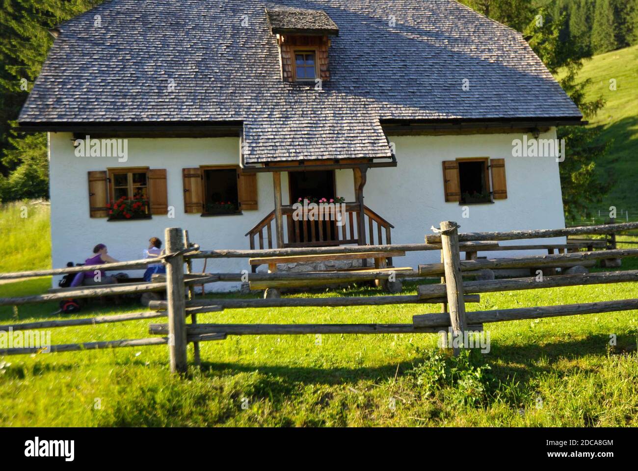 un rifugio nelle alpi con prato verde e. recinzione di legno Foto Stock