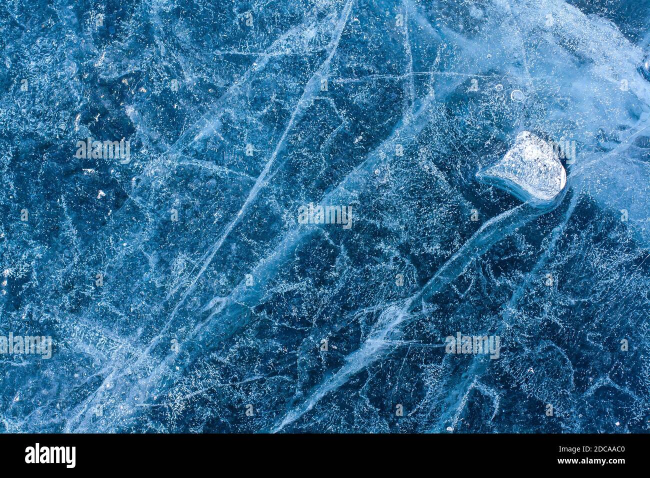 Incredibile struttura di ghiaccio con crepe e bolle d'aria. Poco ghiaccio fuso galleggiare su ghiaccio blu. Modello invernale. Orizzontale. Foto Stock