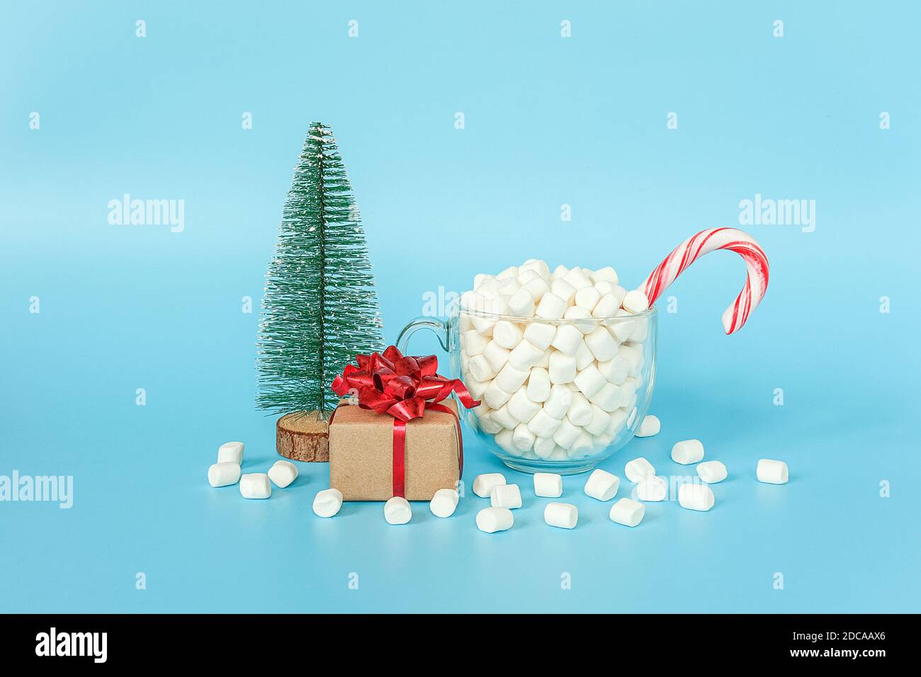 Confezione regalo, albero di natale e tazza di marshmallows con canna di lecca rossa su sfondo blu. Buon Natale o buon anno concetto. Modello per yo Foto Stock