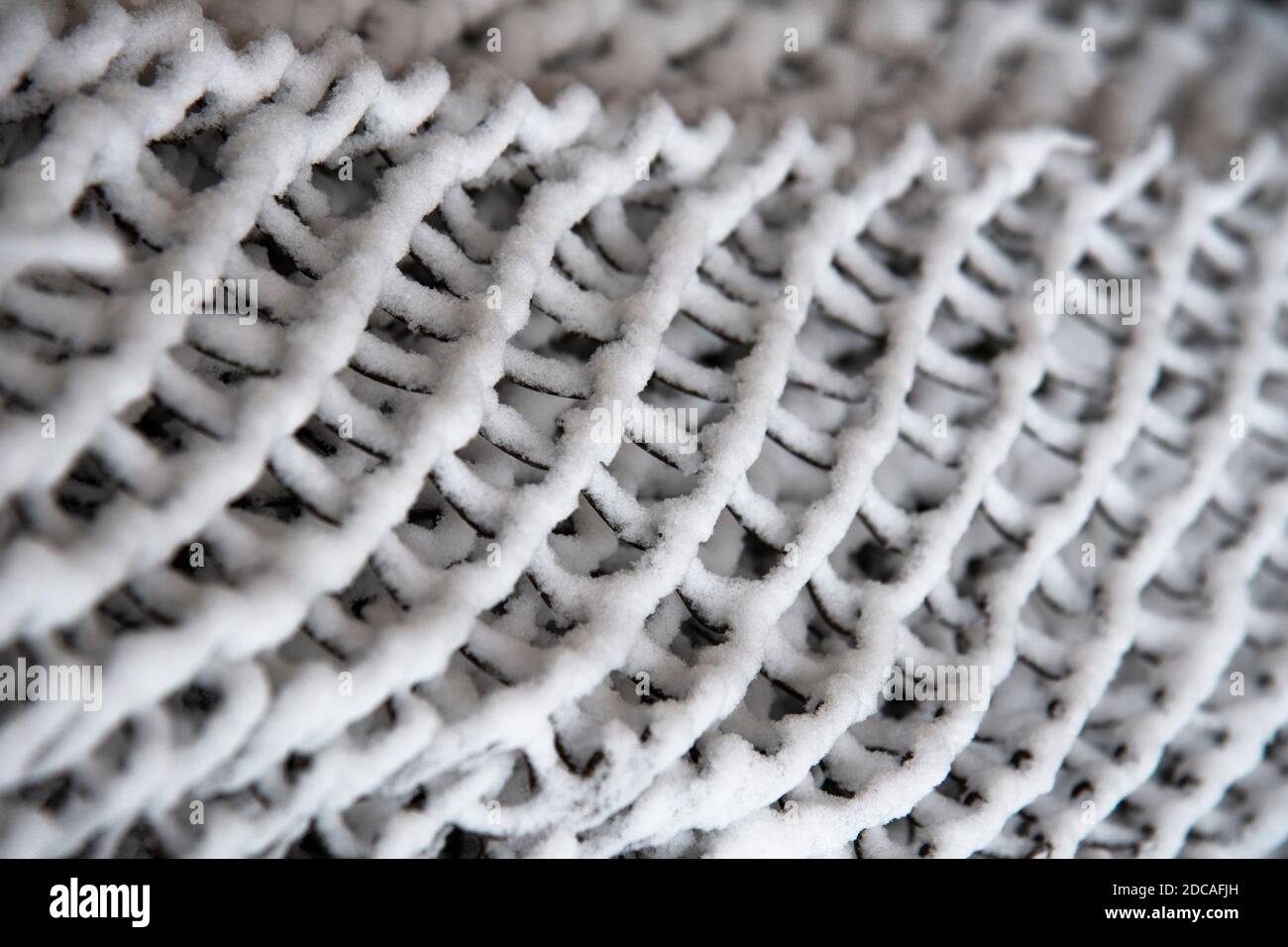 Griglia scura coperta di neve . Sfondo bianco e nero d'inverno astratto Foto Stock