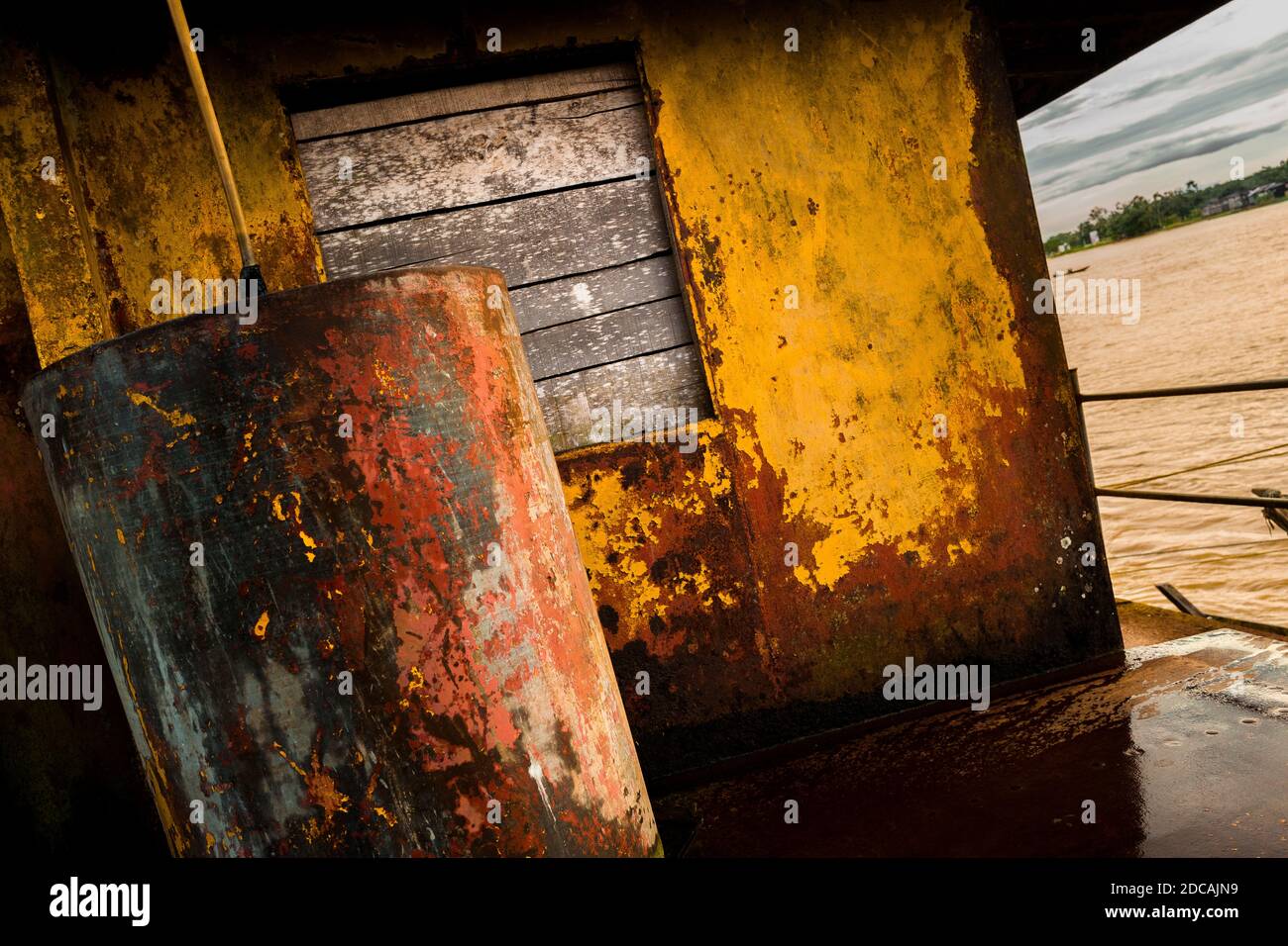 Una finestra a bordo è vista sul ponte di un vecchio dreedge d'oro ancorato nel fiume Atrato a Quibdó, Colombia. Foto Stock