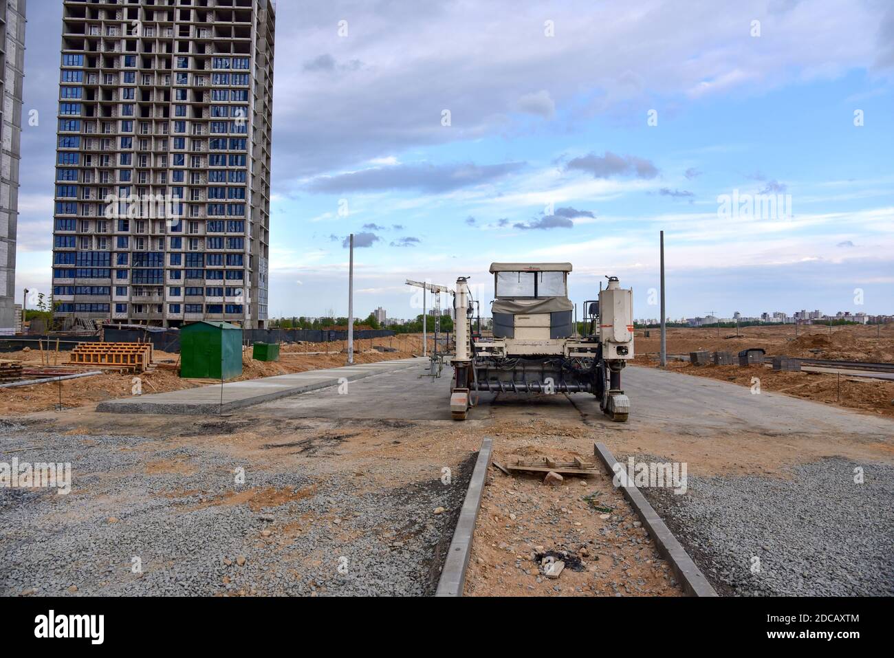 Finitrice Slipform per lavori su strada in cantiere. Pavimentazione stradale in calcestruzzo nel nuovo trimestre. Riparazione di strade in cemento con la nuova tecnologia Foto Stock