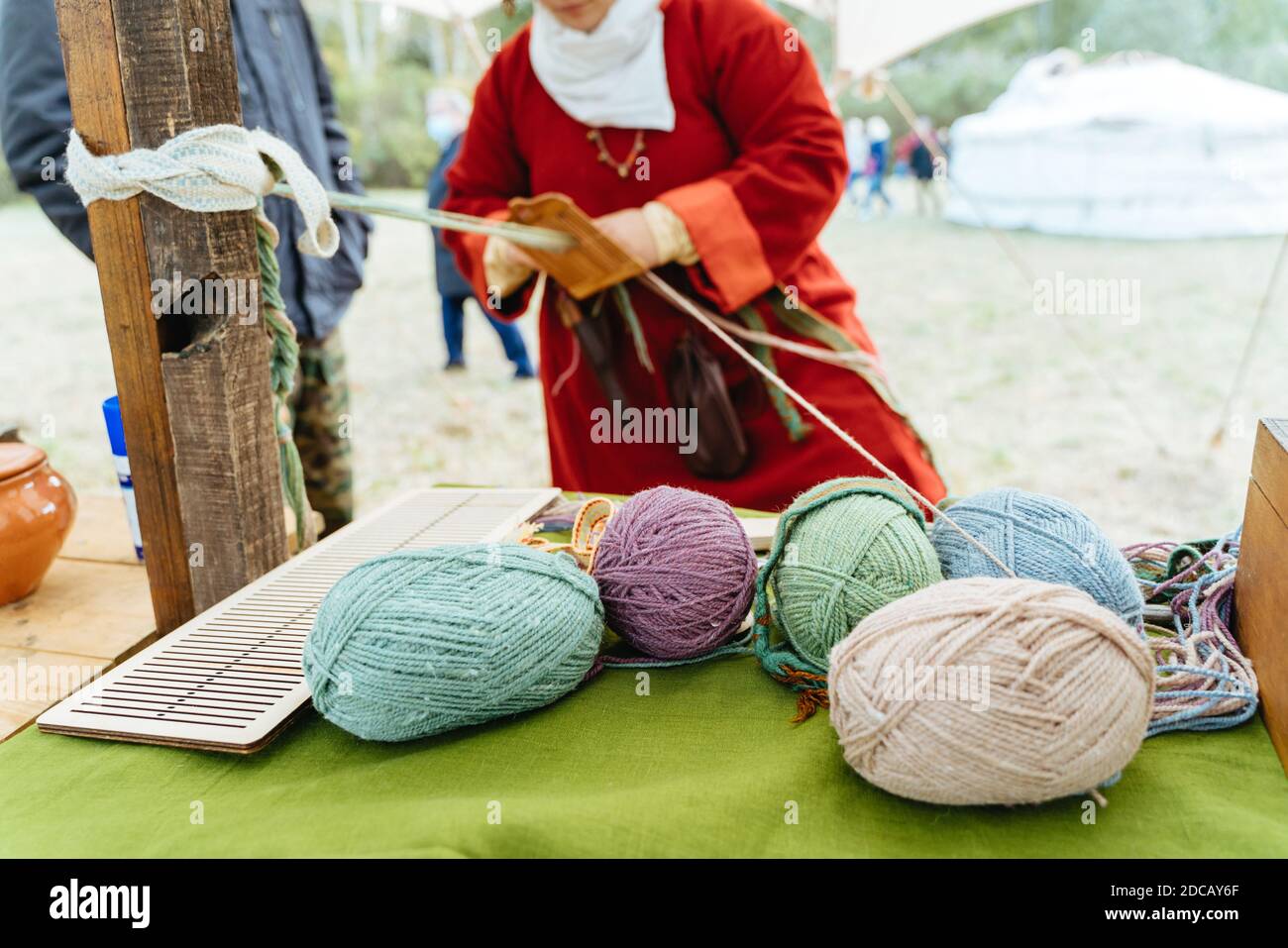 Tessitura artigianale. Donna in abito tradizionale lavora con le mani Foto Stock
