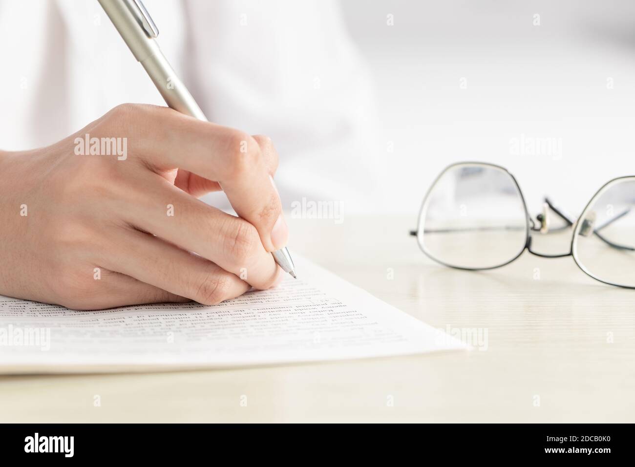 Una mano di donna d'affari che scrive su carta in ufficio Foto Stock Una mano di donna d'affari che scrive su carta in ufficio Foto Stock