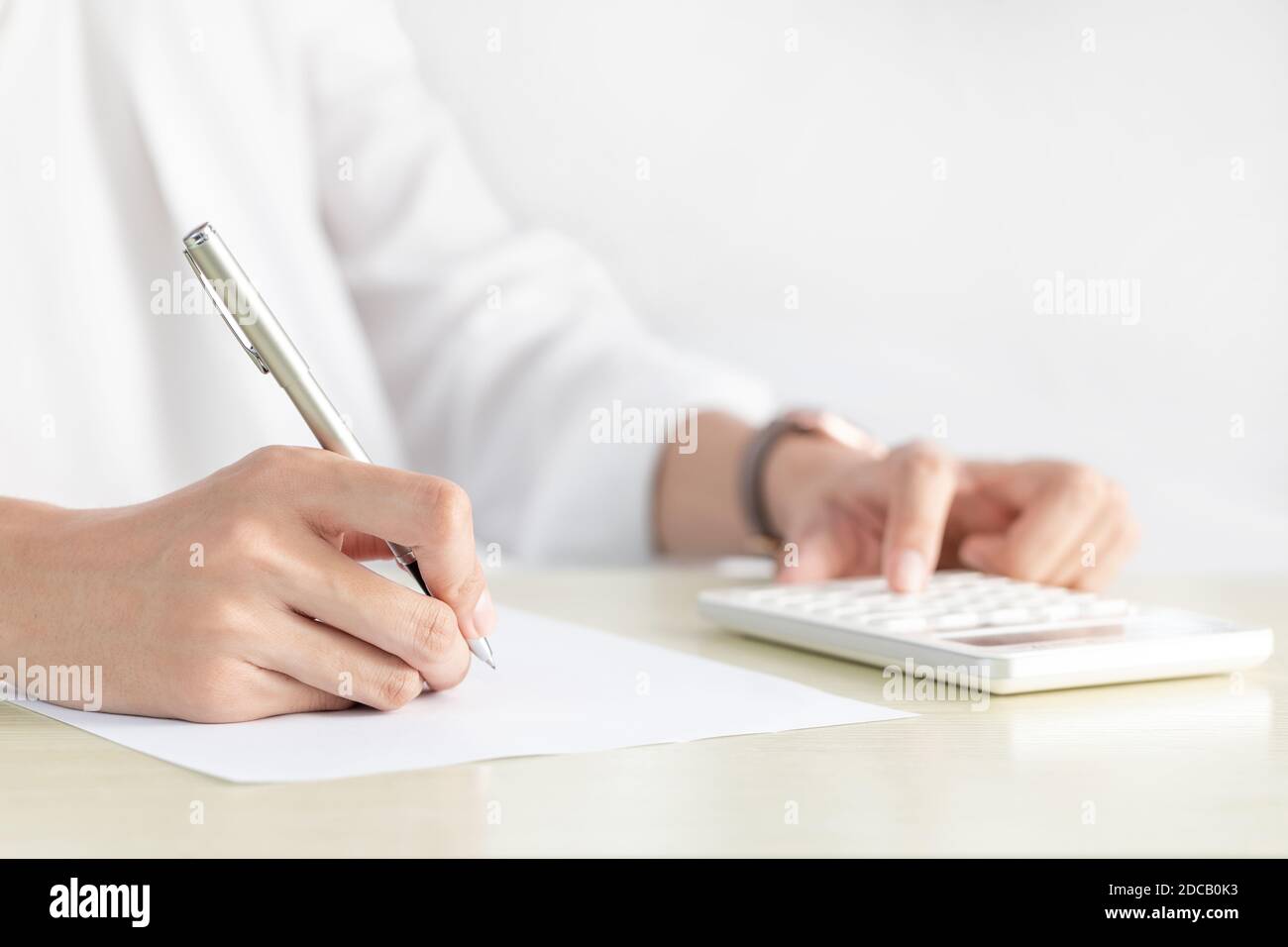 Una mano di donna d'affari che scrive su carta in ufficio Foto Stock Una mano di donna d'affari che scrive su carta in ufficio Foto Stock