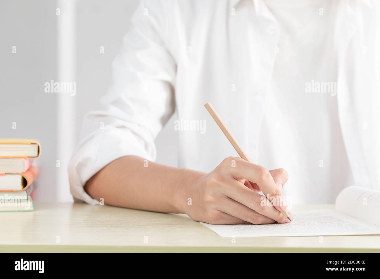 Una mano di donna d'affari che scrive su carta in ufficio Foto Stock Una mano di donna d'affari che scrive su carta in ufficio Foto Stock