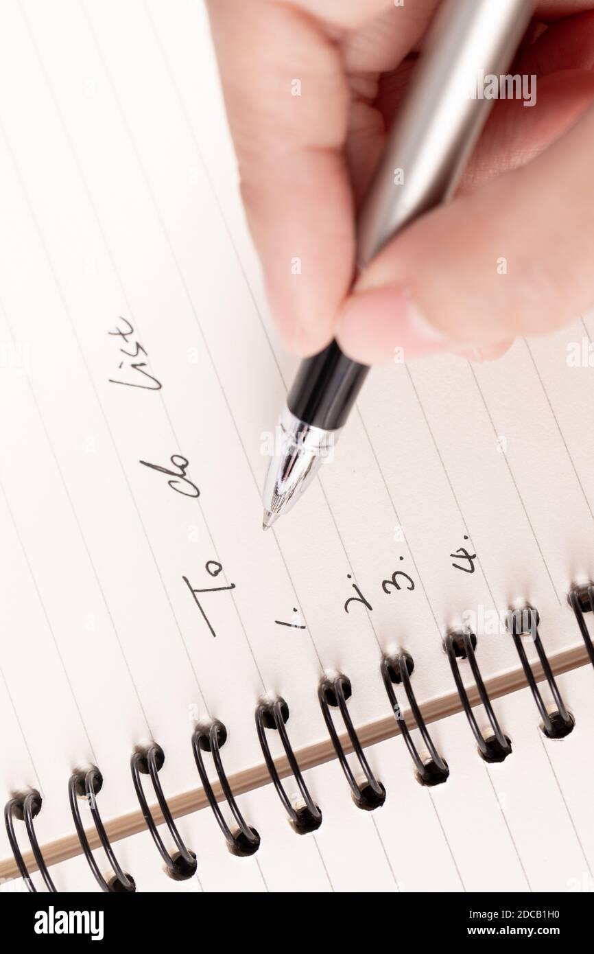 Una mano di donna d'affari che scrive su carta in ufficio Foto Stock Una mano di donna d'affari che scrive su carta in ufficio Foto Stock