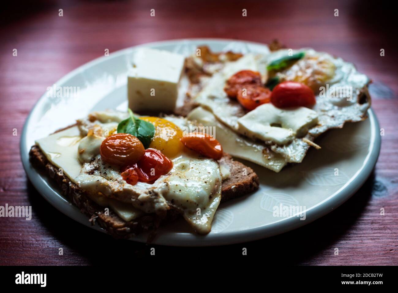 Uova fritte con pomodori e basilico, stile mediterraneo Foto Stock