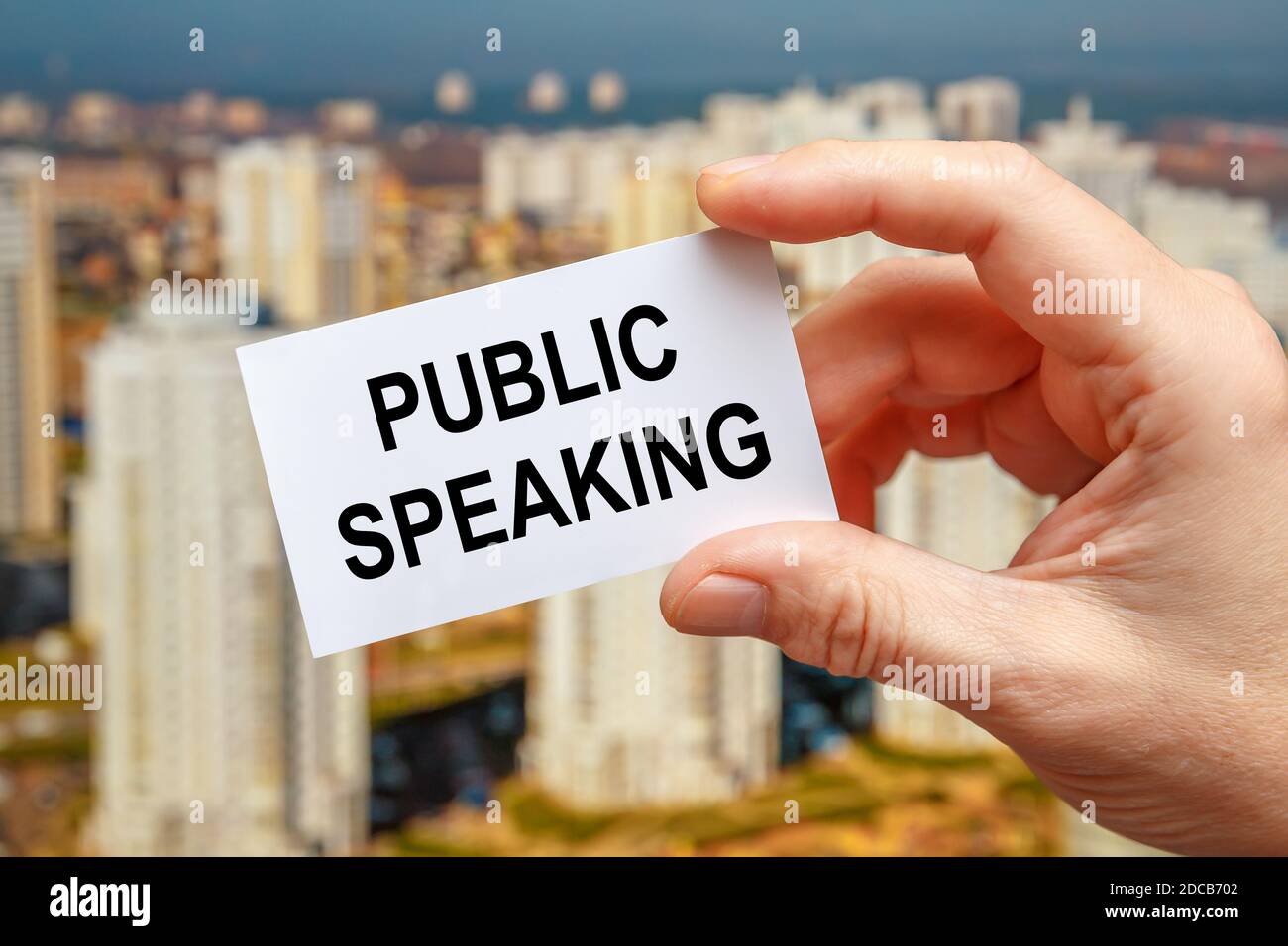 Pubblico parlando - l'iscrizione sulla carta che una persona tiene sullo sfondo della città. Foto Stock